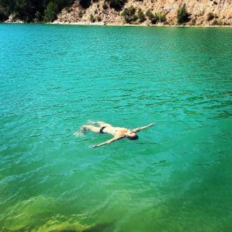 Femme flottant dans une eau turquoise en Sardaigne — Via Magdalena, l'île du Féminin sauvage